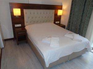 1 dormitorio con 1 cama blanca y 2 toallas en City House, en Estambul