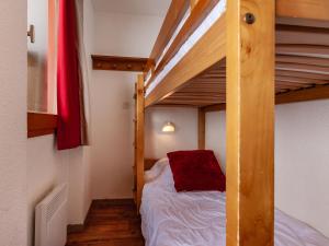1 dormitorio con litera y almohada roja en Résidence Le Pralin en Les Allues