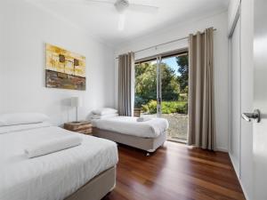 two beds in a room with a window at The Deck in Margaret River Town