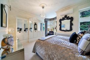 a bedroom with a large bed and a mirror at Finest Retreats - Elm Tree in London