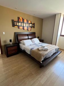 a bedroom with a large bed and a wooden floor at Torre Isos in Cochabamba