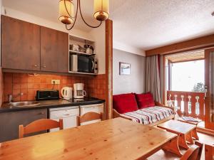 a kitchen and living room with a table and a couch at Résidence Le Pralin in Les Allues