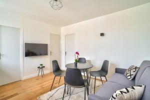 a living room with a couch and a table and chairs at Splendid apartment for 2 persons in Aubervilliers