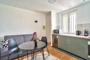 a living room with a couch and a table and a kitchen at Splendid apartment for 2 persons in Aubervilliers