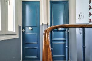 - deux portes bleues dans une chambre avec un escalier dans l'établissement Splendid apartment for 2 persons, à Aubervilliers