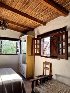 een slaapkamer met een bed, een tafel en een raam bij Casa Los Membrillos in Tafí del Valle