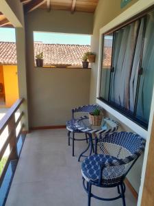 a balcony with two chairs and a table at Sonia Flats - Chalé a 500 metros da Praia da Tartaruga in Búzios