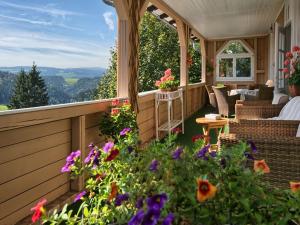 a screened in porch with flowers and furniture at Feldbergblick in Sankt Märgen