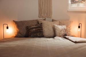 ein Schlafzimmer mit einem Bett mit Kissen und zwei Lampen in der Unterkunft Haus Meierhüsli in Malans