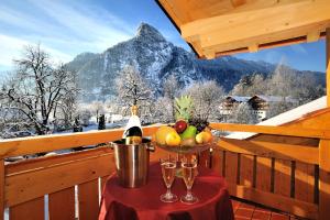 a bowl of fruit on a table on a balcony with a mountain at Landhotel Böld Oberammergau in Oberammergau