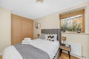 a bedroom with a bed and a window at 2 Bedroom Riverside Apartment near Canary Wharf! in London