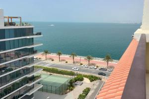 una vista aérea de una pista de tenis frente a un edificio en Luxe Getaways Royal Amwaj Palm Jumeirah Resort Apartment Holiday Home en Dubái