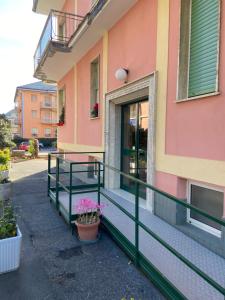 a pink building with a porch with flowers on it at casa Nenne appartamento con due camere da letto in Lavagna