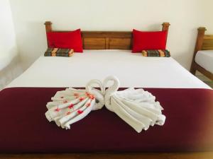 2 asciugamani su un letto con cuscini rossi di LAKE NEST resort a Anuradhapura