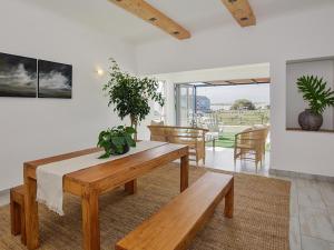 a dining room with a wooden table and benches at 19 Beach Road in Cape Town