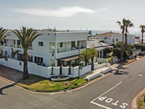 una vista aérea de una casa blanca con palmeras y el océano en 19 Beach Road en Ciudad del Cabo