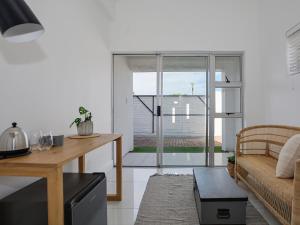 ein Wohnzimmer mit einem Sofa und einem Tisch in der Unterkunft 19 Beach Road in Kapstadt