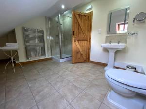 a bathroom with a toilet and a sink and a shower at Clarice Cottage in Eyam