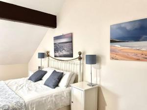 a bedroom with a bed with two blue pillows at Clarice Cottage in Eyam