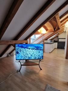 a flat screen tv on a stand in an attic at Modern Chalet Style in traditional village home with free WiFi & optional Wallbox 