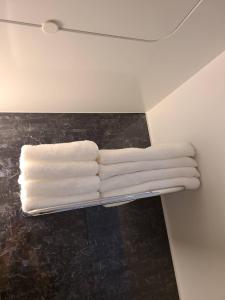 four white towels on a towel rack in a bathroom at 301号N＋ホテル in Tokyo