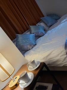 a bed with blue pillows and hats on a table at 301号N＋ホテル in Tokyo