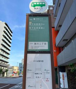 una señal frente a un edificio al lado de una calle en 301号N＋ホテル, en Tokio