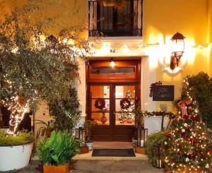 un frente de tienda con un árbol de Navidad delante de él en Boutique hotel El Capricho, en Beniali