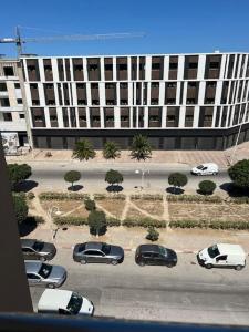 un aparcamiento con coches estacionados frente a un gran edificio en Luxury 2 bedrooms apartment jardin de carthage en Túnez