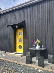a yellow door and a table in front of a building at Unique restored barn with stove in Killybegs