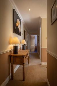 a hallway with a table with a lamp on it at Loch Eyre Oasis in Kensaleyre