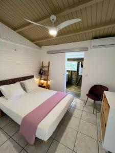 a bedroom with a bed and a ceiling fan at Villa La Belle Creole 4 étoiles in Saint-François