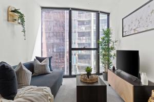 a living room with a couch and a tv at A Chic 2BR Apt Right Next to Melbourne Central in Melbourne
