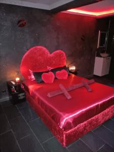 a bedroom with a red bed with a heart on it at L'instant romance Le Romantique in Castelnaudary