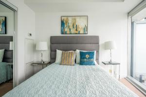 a bedroom with a large bed with blue pillows at GLOBALSTAY. Amazing Downtown Apartments in Toronto