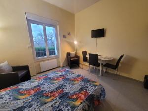 a bedroom with a bed and a table and a window at Studio Rez de Chaussée Meublé in La Roche-Posay