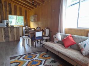 - un salon avec un canapé et une table dans l'établissement Cabañas & Habitaciones Del Alto, à Hornopirén