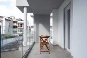 Un petit tabouret est installé sur le balcon d'un bâtiment. dans l'établissement ANSIRO Apartment - Luxury Home, à Scisciano