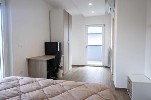 - une chambre avec un lit, un bureau et une télévision dans l'établissement ANSIRO Apartment - Luxury Home, à Scisciano