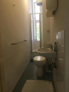 La salle de bains est pourvue de toilettes, d'un lavabo et d'une fenêtre. dans l'établissement Spring Cuddle Nest, à Berlin