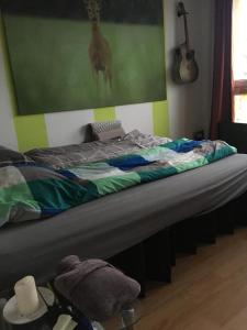 Bett in einem Zimmer mit Foto einer Giraffe in der Unterkunft Spring Cuddle Nest in Berlin