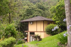 une petite maison sur une colline dans une forêt dans l'établissement Pousada Terra Crua, à Visconde de Mauá