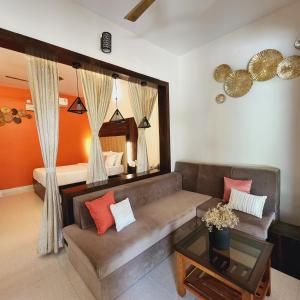 een woonkamer met een bank en een bed bij Riyavar Luxury Homestay in Siddapur