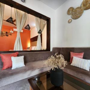 een woonkamer met een bank en een spiegel bij Riyavar Luxury Homestay in Siddapur