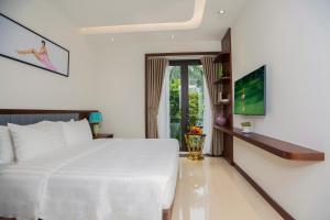 a bedroom with a large white bed and a window at Blubiz Hotel 5 in Hanoi