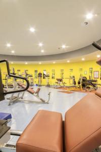 einen Fitnessraum mit mehreren Laufbändern und Trainingsgeräten in der Unterkunft Villaggio Olimpico Sestriere in Sestriere