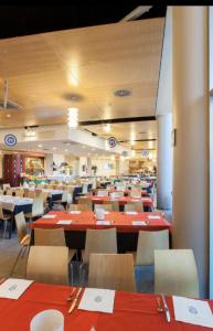 une salle à manger avec des tables et des chaises rouges dans l'établissement Villaggio Olimpico Sestriere, à Sestrières