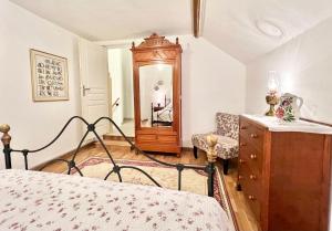 a bedroom with a bed and a dresser and a mirror at Greener Pastures - Normandy Self Catering Gites in La Chapelle-Engerbold