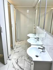 uma casa de banho branca com três lavatórios e espelhos em Double Bedroom near Beach with Private terrace 3rd floor No Lift Room 9 em Oeiras