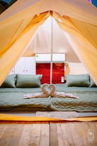 a person laying on a bed in a tent at LALASEA BISTRO (Camping, Food & Drink) in Ha Tien
